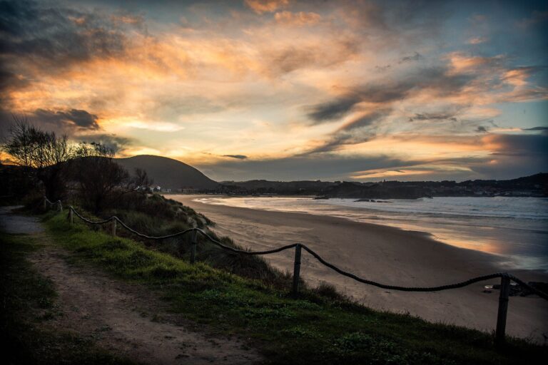 Atardecer con cielo naranja sobre la playa de Ris en Noja, Cantabria