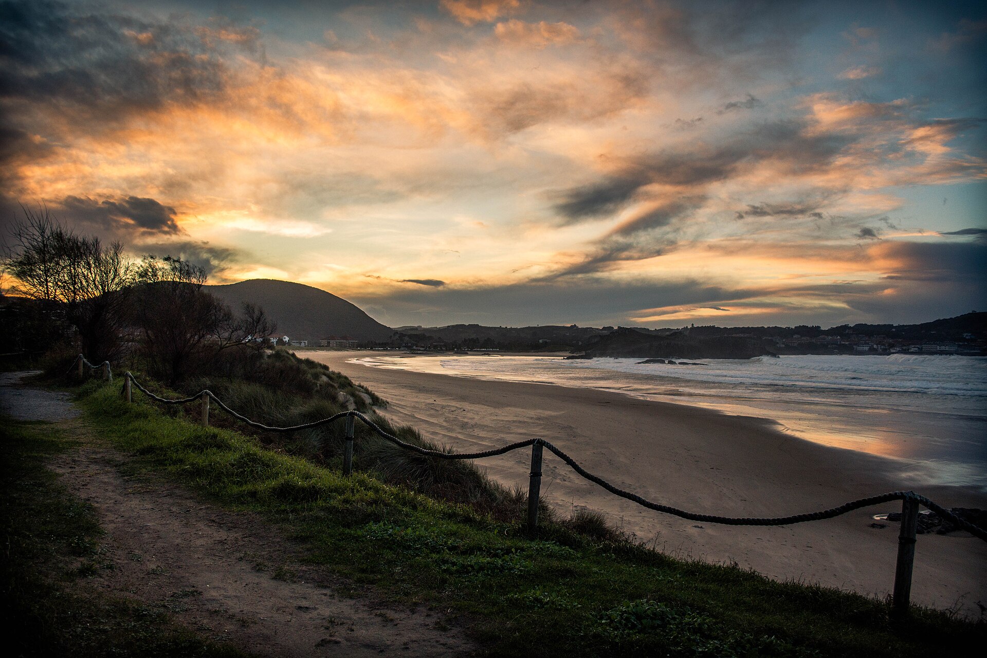 Atardecer con cielo naranja sobre la playa de Ris en Noja, Cantabria